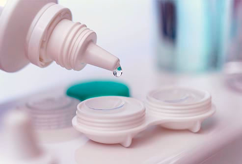 A bottle dripping contact lens solution into a contact lens case