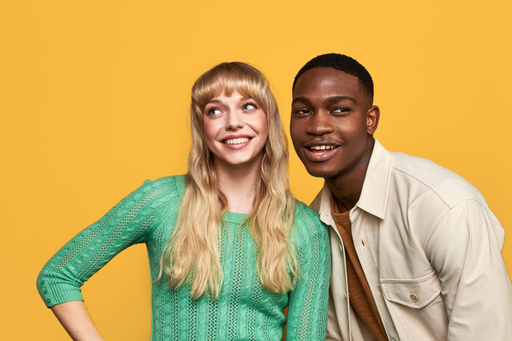 a man and woman in front of a yellow background wearing contact lenses