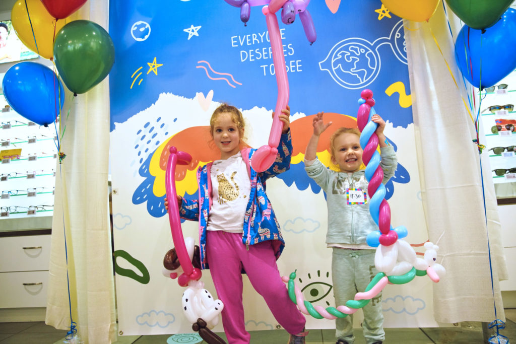 Kids posing in front of a colourful mural