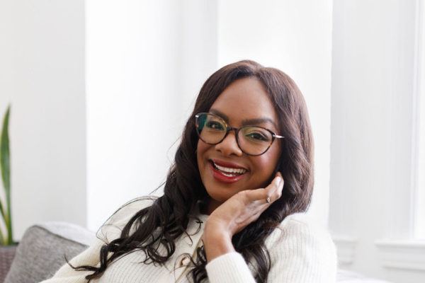 woman wearing cat-eye glasses with white background looking happy